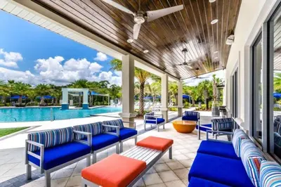 a patio with blue chairs and a pool at 3841 Kalistoga Stylish Villa 7BD Private Pool and Game Room in Kissimmee