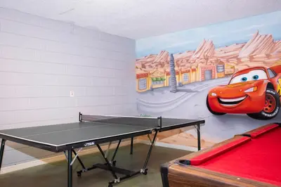 a room with a ping pong table and a mural at Celebrate BR in Orlando