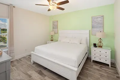 a bedroom with a white bed and a ceiling fan at Lovely Villa Near Disney With Margaritaville Resort And Island H20 Waterpark Access - 2904Or in Orlando