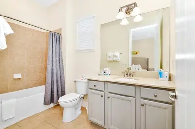 a bathroom with a toilet and a sink and a mirror at Ocean Blue Cottage Near Disney With Private Hot Tub & Margaritaville Resort & Island H20 Waterpark Access - 3012Sr in Orlando
