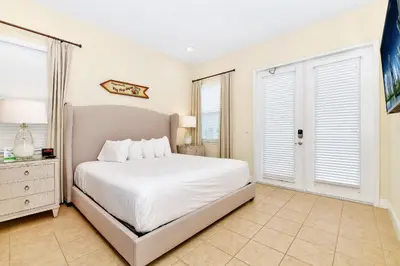 a bedroom with a white bed and two windows at Ocean Blue Cottage Near Disney With Private Hot Tub & Margaritaville Resort & Island H20 Waterpark Access - 3012Sr in Orlando