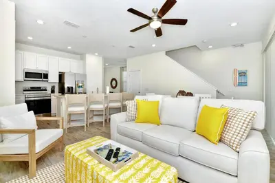 a living room with a white couch and yellow pillows at Serene Villa Near Disney With Margaritaville Resort & Island H20 Access - 8147Cp in Orlando