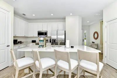 a kitchen with a large white island with four chairs at Serene Villa Near Disney With Margaritaville Resort & Island H20 Access - 8147Cp in Orlando