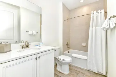 a white bathroom with a toilet and a sink at Serene Villa Near Disney With Margaritaville Resort & Island H20 Access - 8147Cp in Orlando