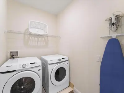 a laundry room with a washing machine and a washer at Sunshine Villa Near Disney With Margaritaville Resort & Island H20 Waterpark Access - 2922Cl in Orlando
