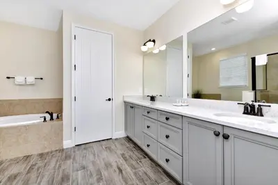 a bathroom with two sinks and a tub and a large mirror at Blue Moon Luxurious Cottage With Private Pool Near Disney With Margaritaville Resort & Island H2O Access - 8073Su in Orlando
