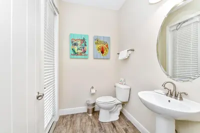 a bathroom with a toilet and a sink and a mirror at Sunrise Cottage With Private Pool Near Disney With Margaritaville Resort & Island H2O Access - 8017Su in Orlando