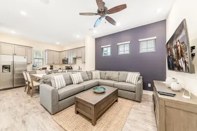 a living room with a couch and a table at Seven Saturdays Cottage Near Disney With Margaritaville Resort & Island H2O Access - 3032Sp in Orlando