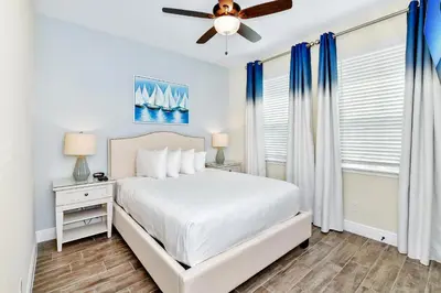 a bedroom with a bed and a ceiling fan at Pearly White Villa Near Disney With Margaritaville Resort & Island H2O Access - 3061Cs in Orlando