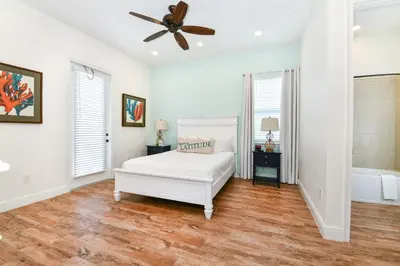 a white bedroom with a bed and a ceiling fan at Crystal Cottage Near Disney With Margaritaville Resort & Island H2O Access - 8033Ls in Orlando