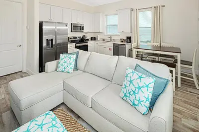 a living room with a couch and a kitchen at Sea Shell Blue Cottage Near Disney With Private Pool And Margaritaville Resort & Island H2O Access - 8039Kd in Orlando