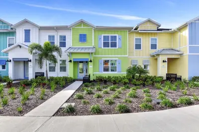 a house with yellow and green paint at Tropical Green Villa Near Disney With Margaritaville Resort & Island H20 Access - 8142Cp in Kissimmee