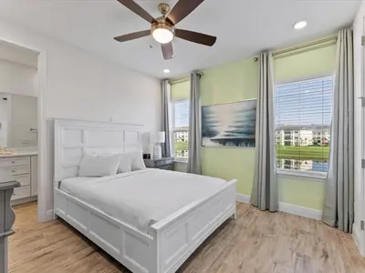a bedroom with a white bed and a ceiling fan at Pink Paradise Villa Near Disney With Margaritaville Resort & Island H20 Waterpark Access - 3121Cs in Orlando