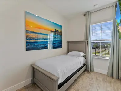 a bedroom with a bed and a painting on the wall at Pink Paradise Villa Near Disney With Margaritaville Resort & Island H20 Waterpark Access - 3121Cs in Orlando