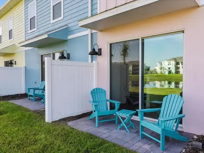 two blue chairs sitting on a patio in front of a house at Pink Paradise Villa Near Disney With Margaritaville Resort & Island H20 Waterpark Access - 3121Cs in Orlando