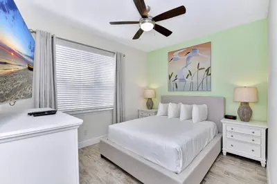 a bedroom with a white bed and a ceiling fan at Blissful Pink Villa Near Disney With Margaritaville Resort & Island H20 Access - 8103Cp in Orlando
