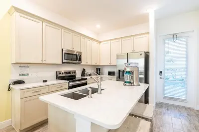 a kitchen with white cabinets and a counter top at Vibrant Cottage With Private Pool Near Disney With Margaritaville Resort & Island H2O Access - 8043Kd in Orlando