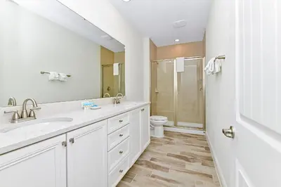 a white bathroom with a sink and a toilet at Cool Cottage Near Disney With Margaritaville Resort & Island H20 Waterpark Access - 3184Cs in Orlando