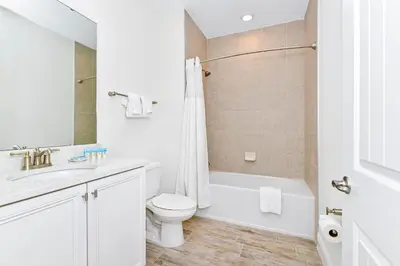 a white bathroom with a toilet and a tub and a sink at Dreamy Villa Near Disney With Margaritaville Resort & Island H2O Access - 3020Cs in Orlando
