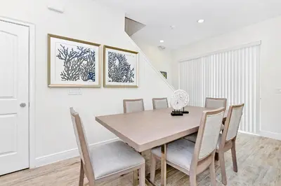 a dining room with a wooden table and chairs at Dreamy Villa Near Disney With Margaritaville Resort & Island H2O Access - 3020Cs in Orlando