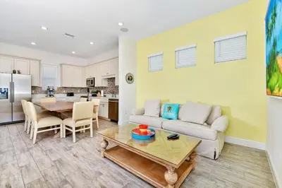 a living room with a couch and a table at Sunny Cottage Near Disney With Margaritaville Resort & Island H20 Waterpark Access - 3013Sp in Orlando