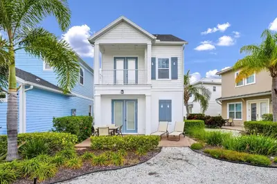 a house with palm trees in front of it at Caraway Cove Cottage Near Disney With Margaritaville Resort & Island H2O Access - 8024Su in Orlando