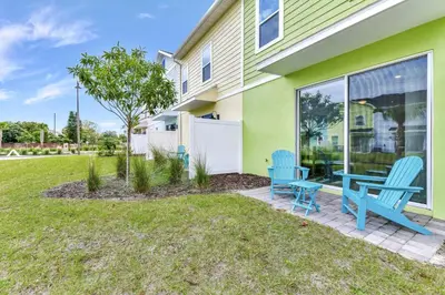 a patio with two blue chairs in front of a house at Making Memories Villa Near Disney With Margaritaville Resort & Island H20 Access - 8115Cp in Kissimmee