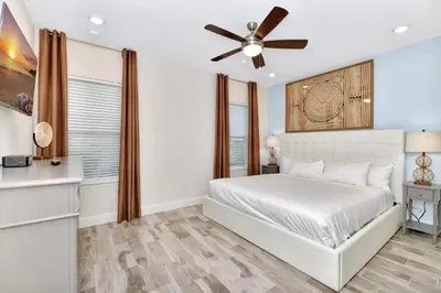 a bedroom with a white bed and a ceiling fan at Making Memories Villa Near Disney With Margaritaville Resort & Island H20 Access - 8115Cp in Kissimmee