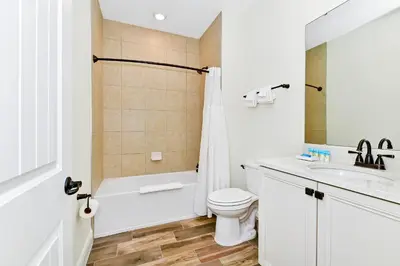 a white bathroom with a toilet and a sink at Tropical Orange Villa Near Disney With Margaritaville Resort & Island H20 Waterpark Access - 2920Cs in Orlando
