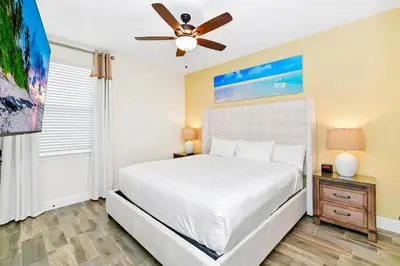 a bedroom with a bed and a ceiling fan at Tropical Orange Villa Near Disney With Margaritaville Resort & Island H20 Waterpark Access - 2920Cs in Orlando