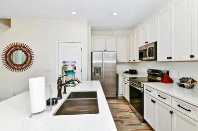a kitchen with white cabinets and a stainless steel refrigerator at Tropical Orange Villa Near Disney With Margaritaville Resort & Island H20 Waterpark Access - 2920Cs in Orlando