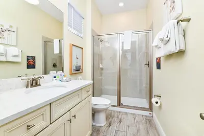 a bathroom with a shower and a toilet and a sink at Seashell Cream Cottage With Private Pool Near Disney With Margaritaville Resort & Island H2O Access - 8037St in Orlando