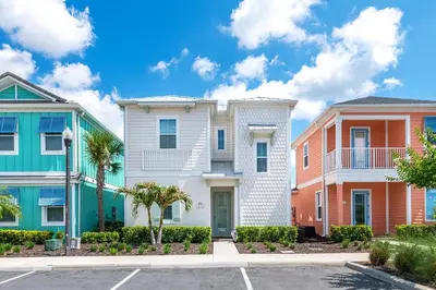 a row of colorful houses in a parking lot at Seashell Cream Cottage With Private Pool Near Disney With Margaritaville Resort & Island H2O Access - 8037St in Orlando