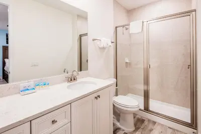 a white bathroom with a toilet and a shower at Pearly White Villa Near Disney With Margaritaville Resort & Island H20 Waterpark Access - 2924Cs in Orlando