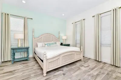 a white bedroom with a bed and two windows at This Pink Cottage Near Disney With Margaritaville Resort & Island H20 Access - 8141Su in Orlando