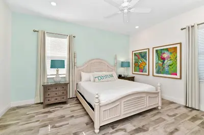 a white bedroom with a bed and two windows at This Pink Cottage Near Disney With Margaritaville Resort & Island H20 Access - 8141Su in Orlando