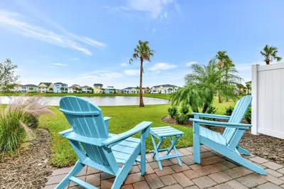 two blue chairs and a table on a patio at Breezy Blue Villa Near Disney With Margaritaville Resort & Island H20 Waterpark Access - 2997Cs in Orlando