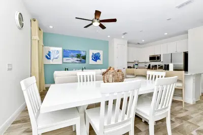 a white dining room with a white table and chairs at Breezy Blue Villa Near Disney With Margaritaville Resort Access - 3120Cs in Orlando
