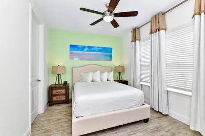 a bedroom with a white bed and a ceiling fan at Blossom Villa Near Disney With Margaritaville Resort And Island H20 Waterpark Access - 2911Cl in Orlando