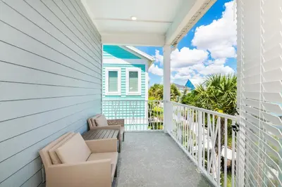 a balcony with two chairs and a house at Beautiful Cottage With Hot Tub Near Disney With Margaritaville Resort & Island H2O Access - 8053Ls in Orlando