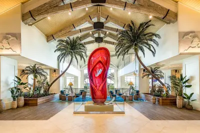 a large red surfboard in a lobby with palm trees at Beautiful Cottage With Hot Tub Near Disney With Margaritaville Resort & Island H2O Access - 8053Ls in Orlando
