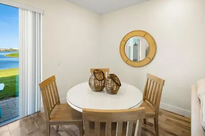 a dining room with a table and chairs and a mirror at Lime Green Villa Near Disney With Margaritaville Resort & Island H20 Waterpark Access - 2944Or in Orlando