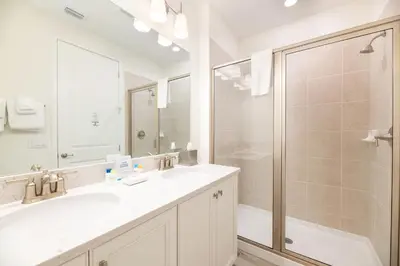 a white bathroom with a shower and a sink at Dreamy Cottage With Private Pool Near Disney And Margaritaville Resort & Island H2O Amenities - 8019Kd in Orlando