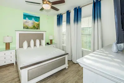 a white bedroom with a bed and a ceiling fan at Beautiful Villa Near Disney With Margaritaville Resort & Island H20 Waterpark Access - 2933Cs in Orlando