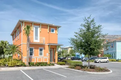 a orange building with a palm tree in a parking lot at Shore To Please Cottage Near Disney With Margaritaville Resort & Island H2O Access - 3044Sp in Orlando