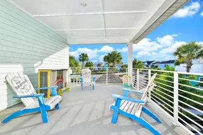 a porch with blue and white chairs on it at Palm Tree Paradise Cottage Private Pool Near Disney With Margaritaville Resort & Island H20 Access - 8109Su in Orlando