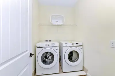 a white laundry room with a washer and dryer at Pink Bliss Villa Near Disney With Margaritaville Resort & Island H20 Access - 3205Cs in Orlando