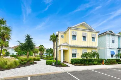 a yellow house with palm trees in a parking lot at Sunny Yellow Cottage Near Disney With Margaritaville Resort & Island H20 Waterpark Access - 2995La in Orlando