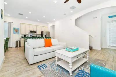 a living room with a couch and a table at Sunny Yellow Cottage Near Disney With Margaritaville Resort & Island H20 Waterpark Access - 2995La in Orlando