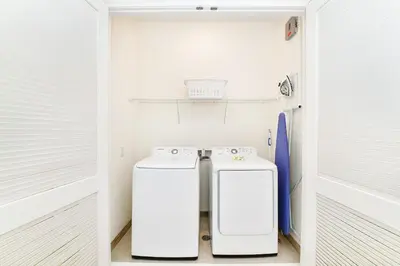 a laundry room with two washer and dryer at Sunny Yellow Cottage Near Disney With Margaritaville Resort & Island H20 Waterpark Access - 2995La in Orlando
